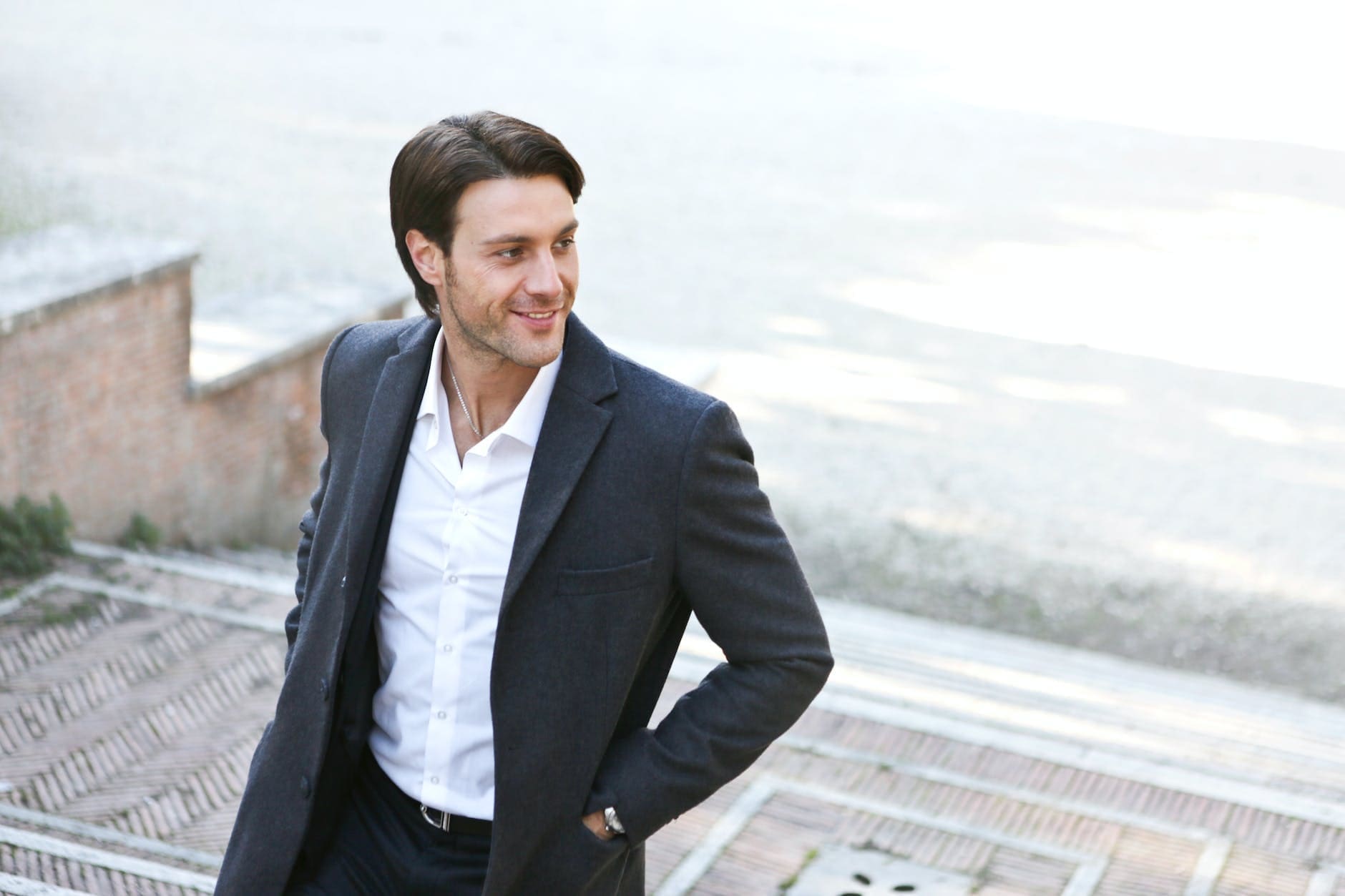 man in white dress shirt and black blazer standing outside building