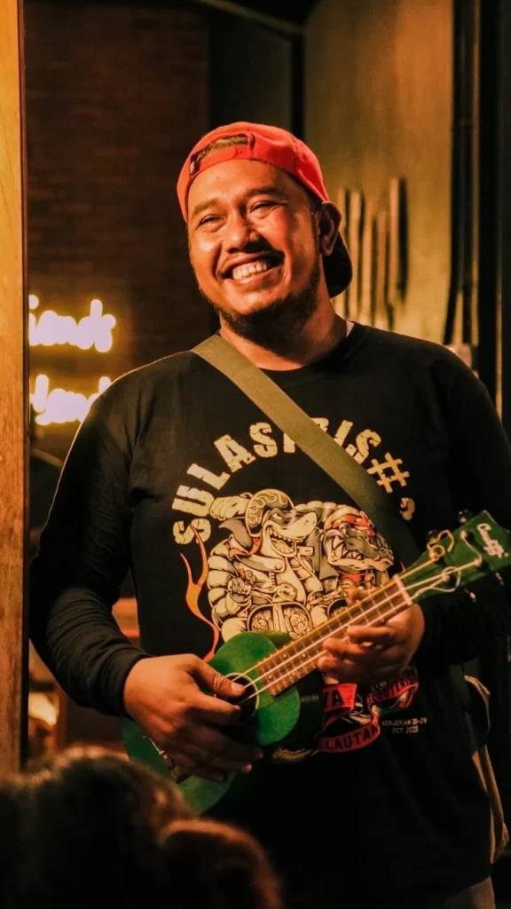 joyful musician playing ukulele at night party